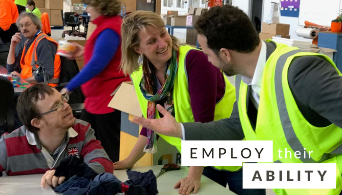 image of two people in high vis talking to a seated man with a watermark of "employ their ability"