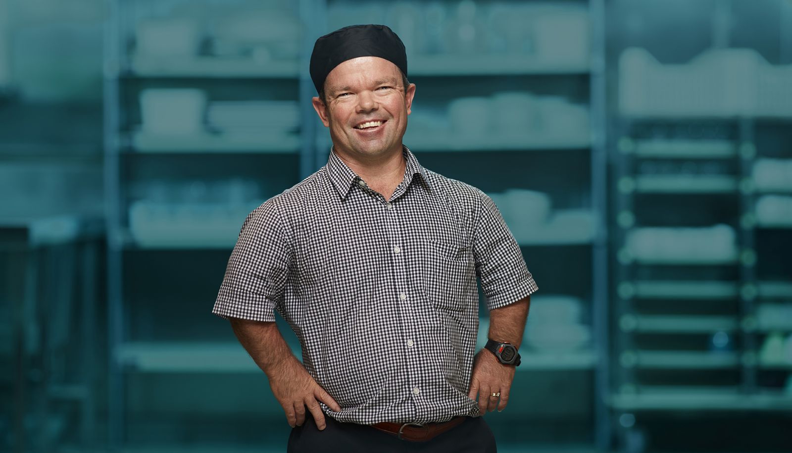 Kevin Green standing in a button-up shirt and a bakers cap