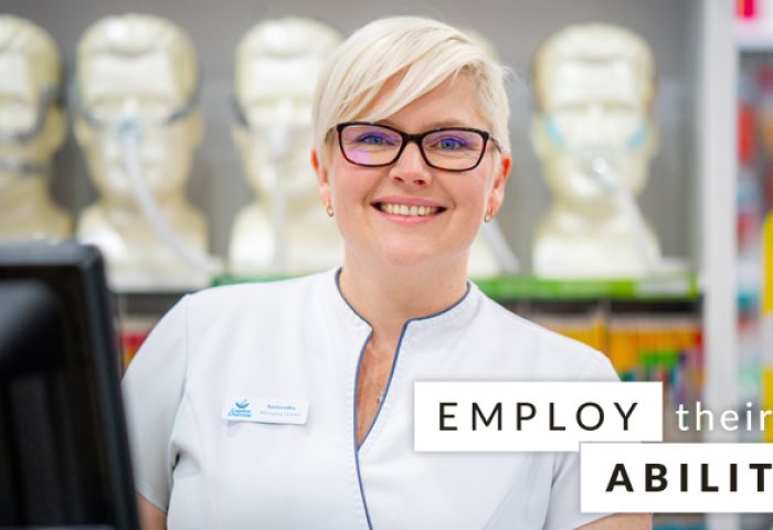 lady smiling behind Employ their Ability slogan