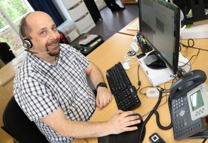 Photo: Daniel Pistritto at his workstation with assistive hearing devices funded by the Employment Assistance Fund (Source: Blamey Saunders hears)