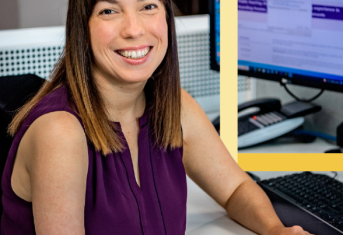 Lady with a physical disability sitting at her desk smiling