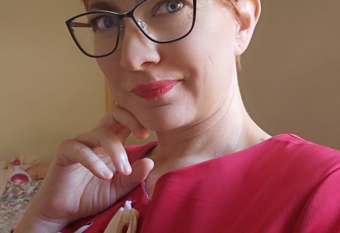 photo of Tegan in a red shirt and glasses.