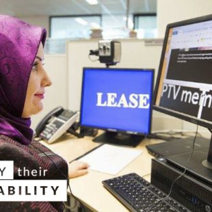 Neslihan Sari, Paralegal at Public Transport Victoria at her desk. Neslihan is looking at her computer and wearing a headset.