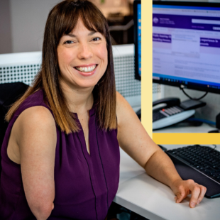 Lady with a physical disability sitting at her desk smiling